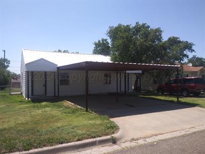 a front view of house with yard and trees in the background