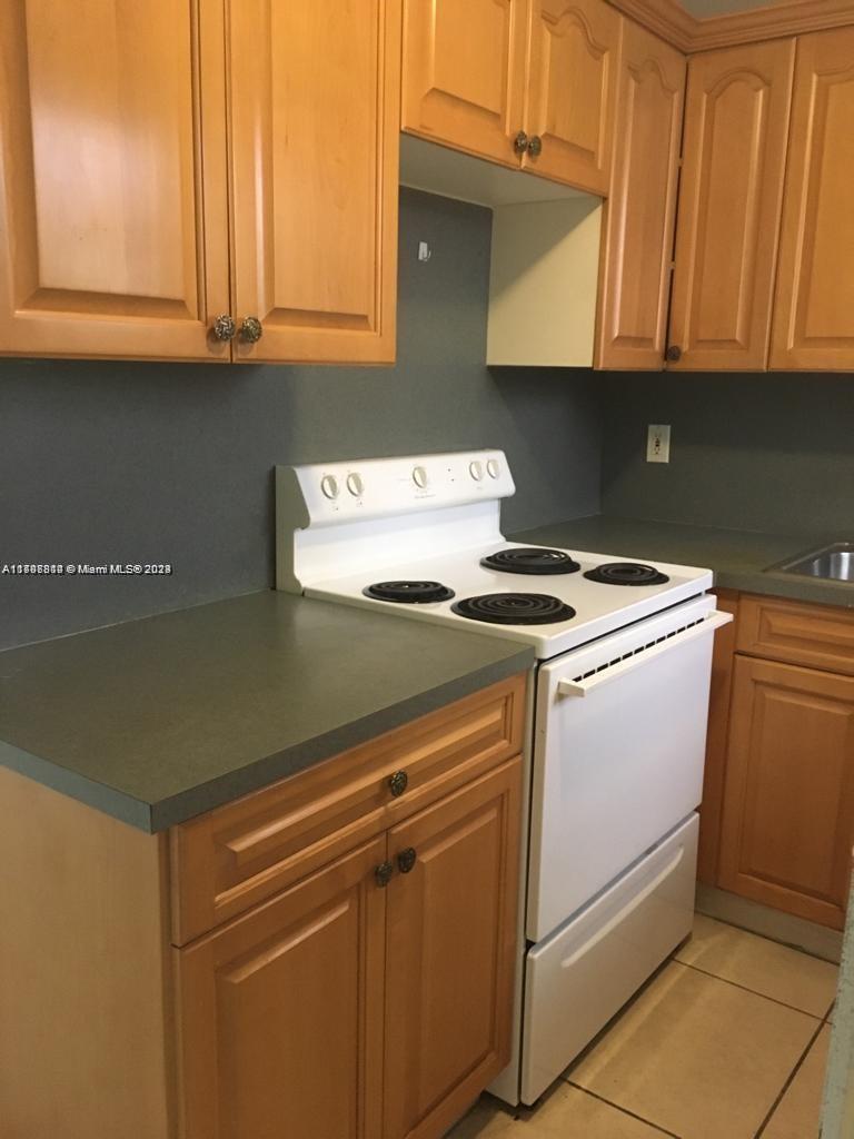 a view of kitchen with granite countertop cabinets and a stove top oven