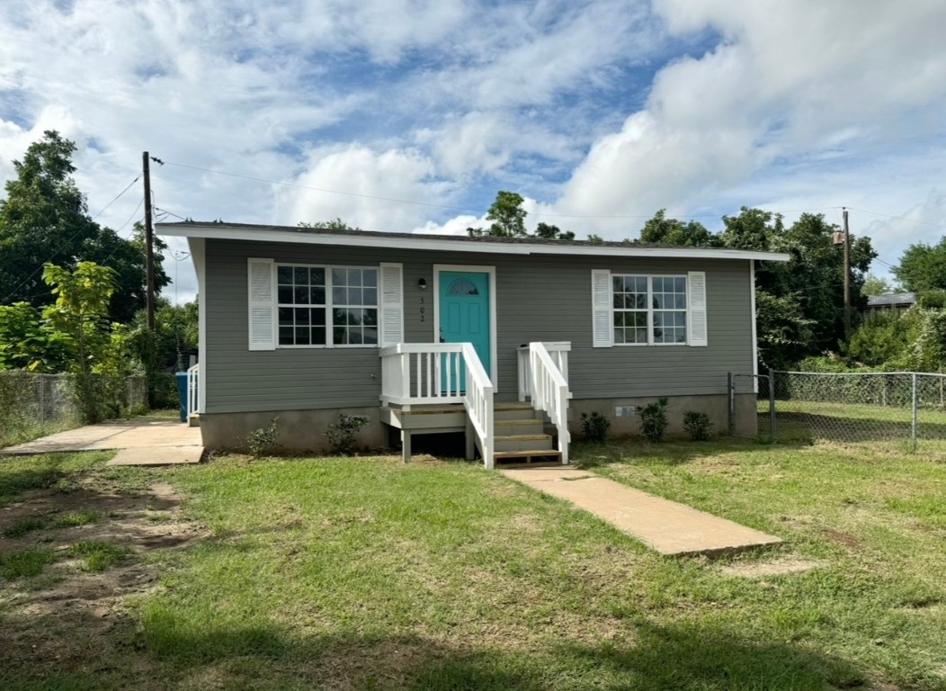 a view of a house with backyard and a tree