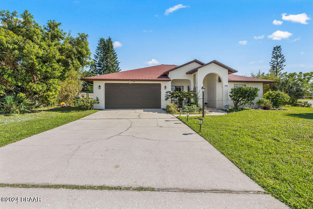 a front view of a house with yard and green space