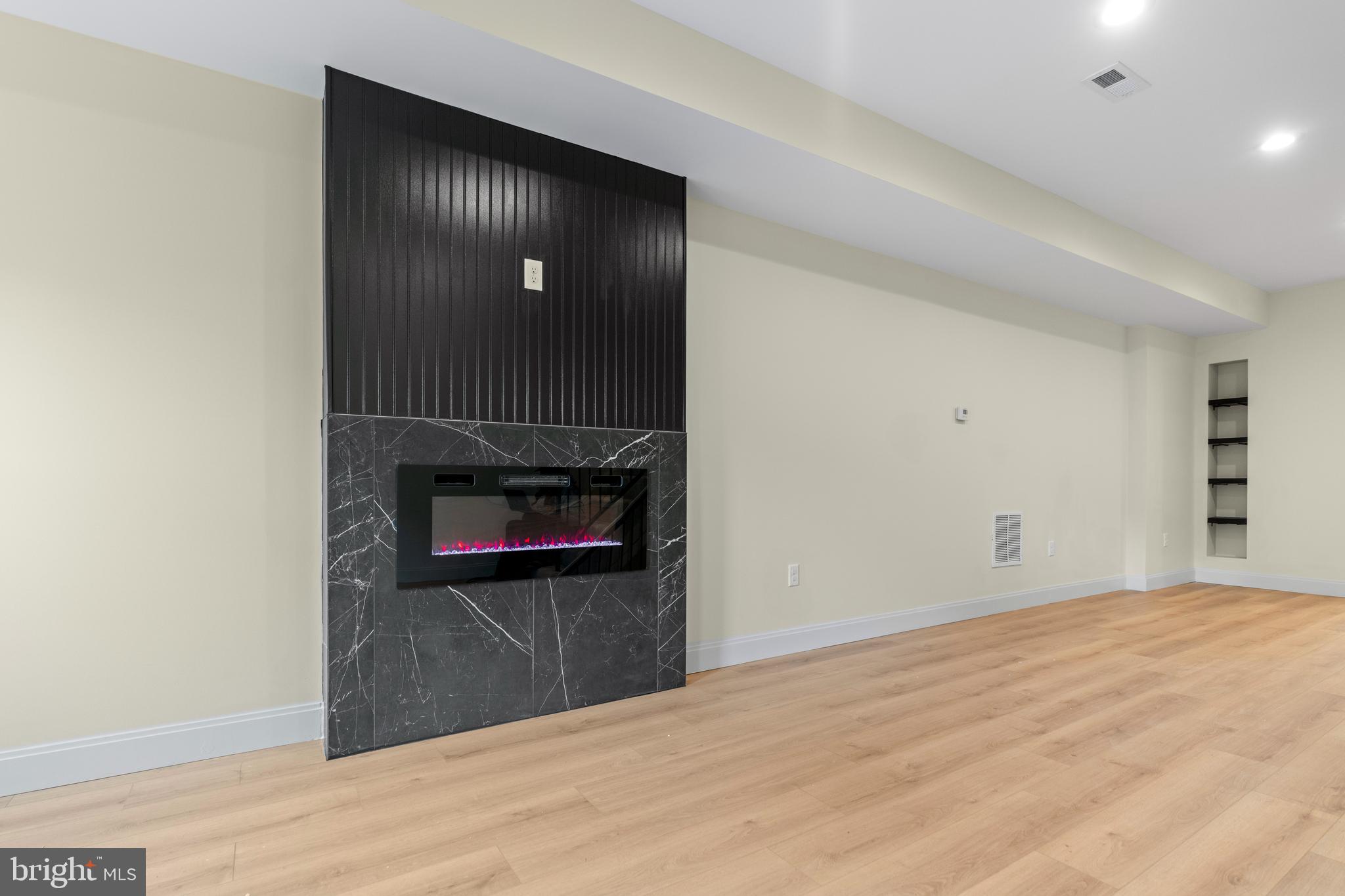 a view of a hallway with wooden floor and a fireplace