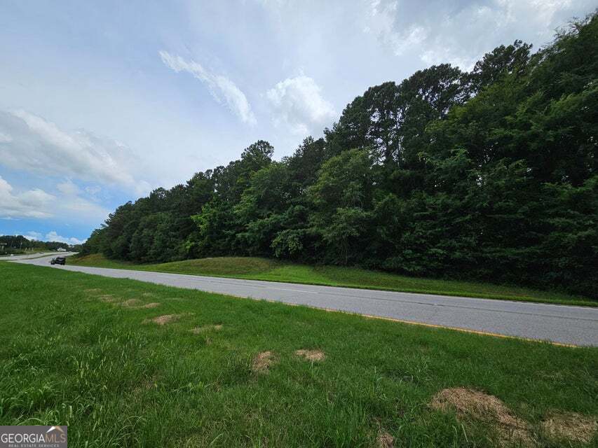 a view of field with grass and trees in the background