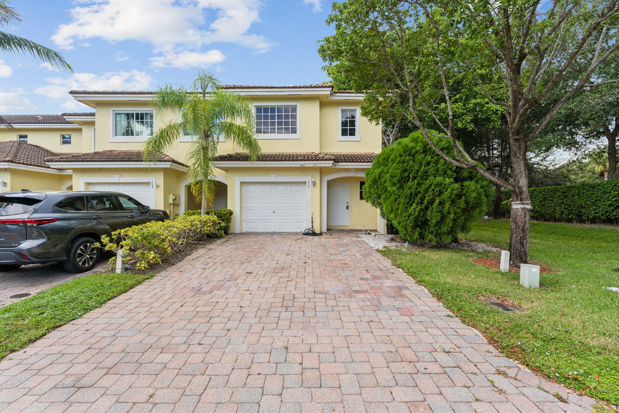 a front view of a house with a yard and trees