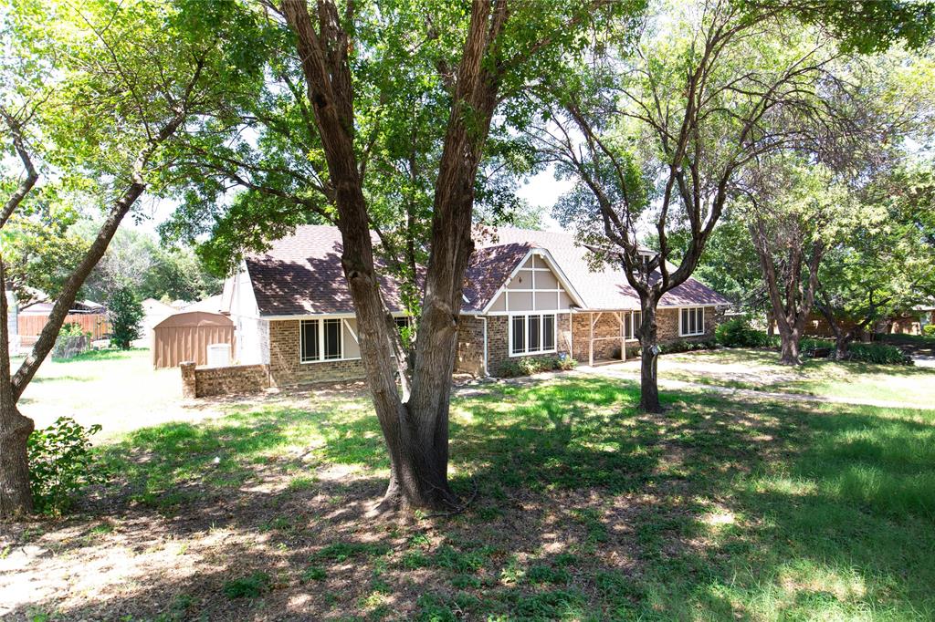 a front view of a house with yard and tree