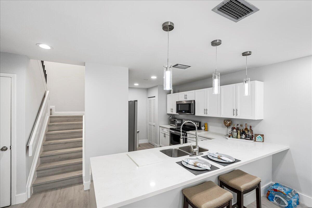 a kitchen with kitchen island white cabinets and stainless steel appliances