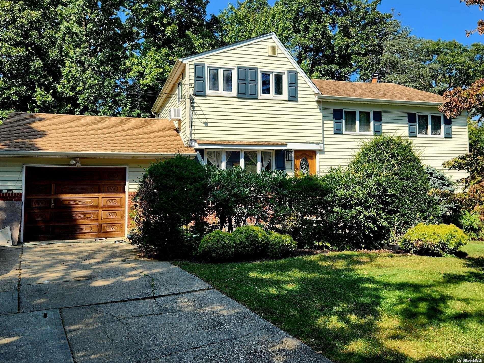 a front view of a house with a yard and potted plants