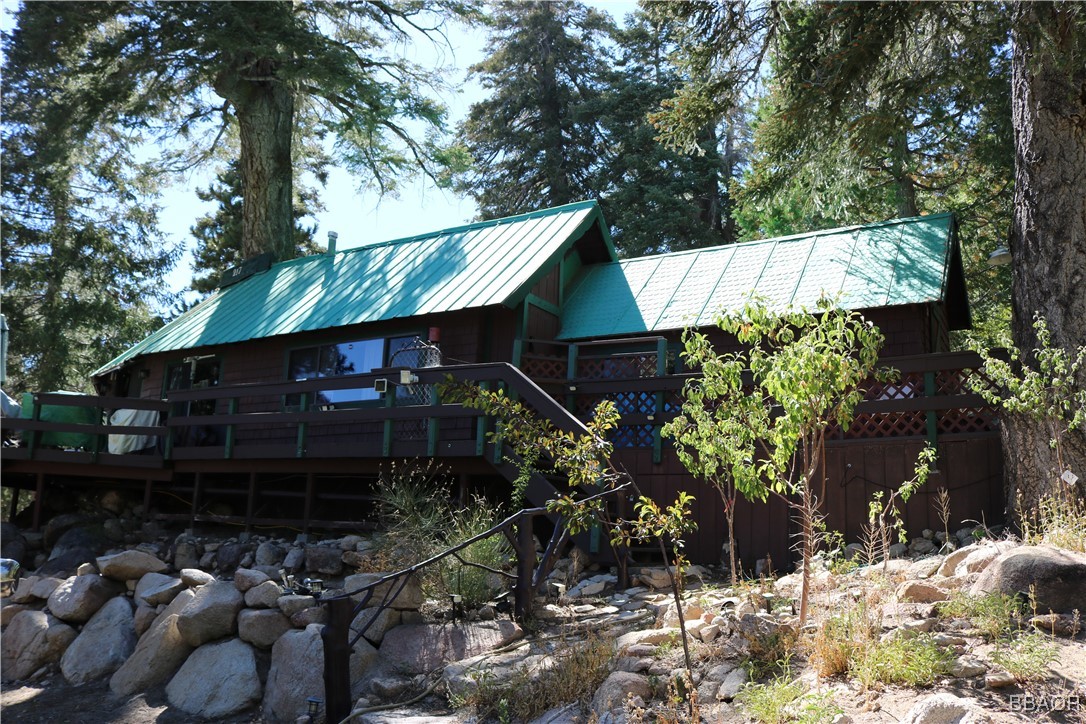 a view of a house with a yard and large trees