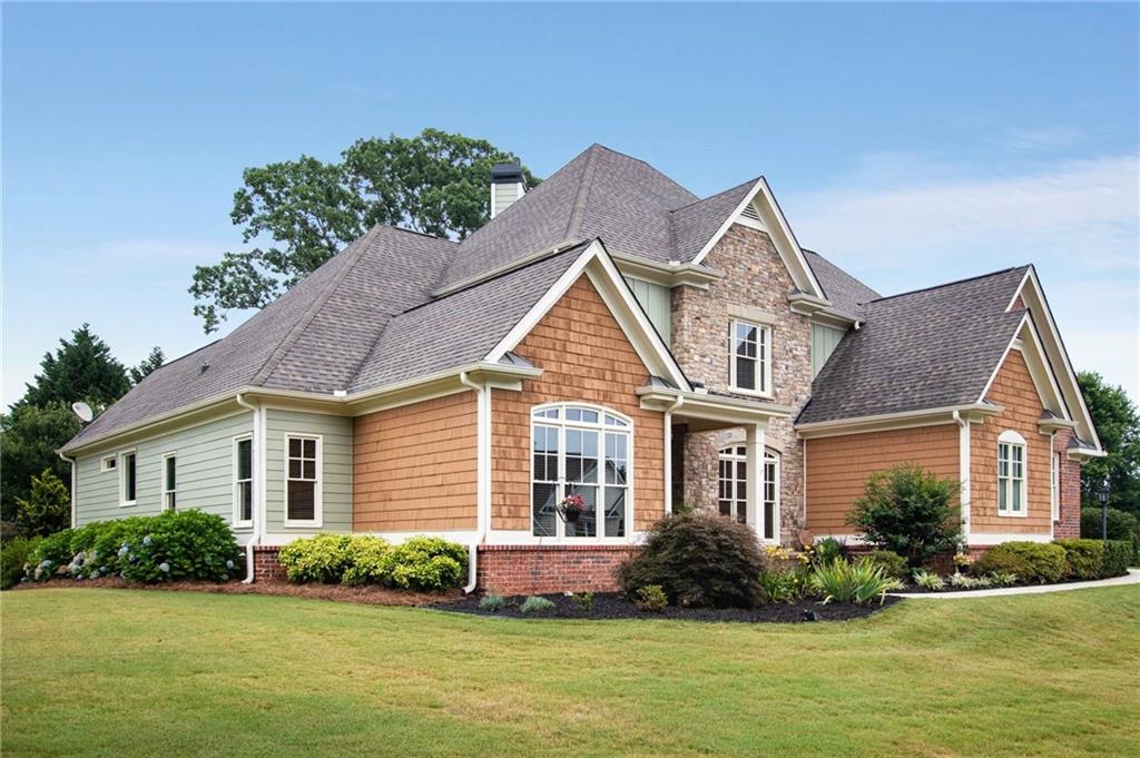 a front view of a house with a yard and potted plants