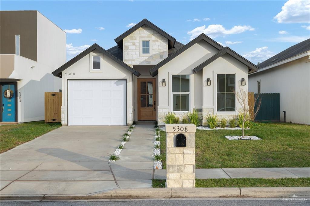 View of front of home featuring a front yard and a garage