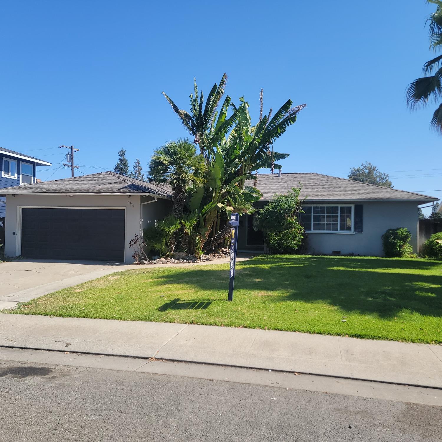 a front view of a house with a garden and yard