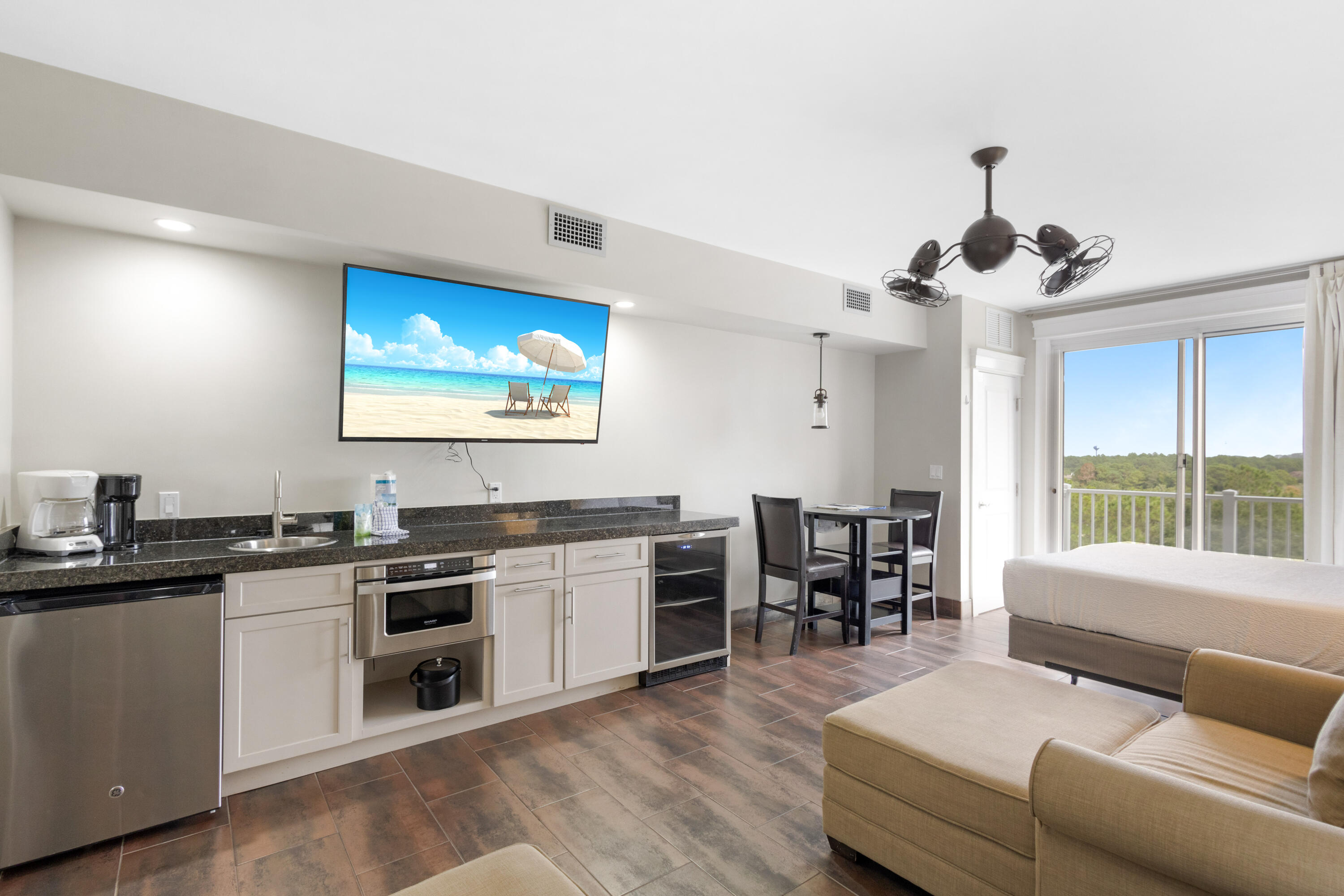 a view of a kitchen with kitchen island a stove a sink a dining table and chairs