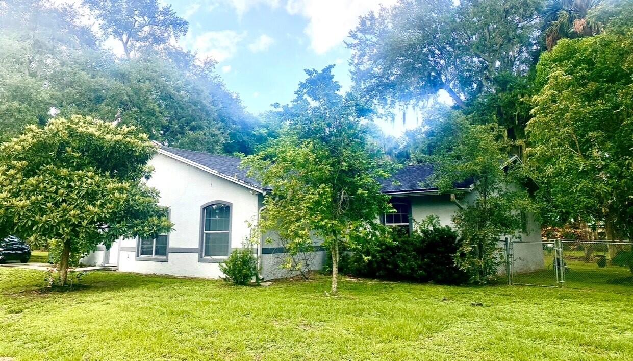 a view of a house with a yard and sitting area