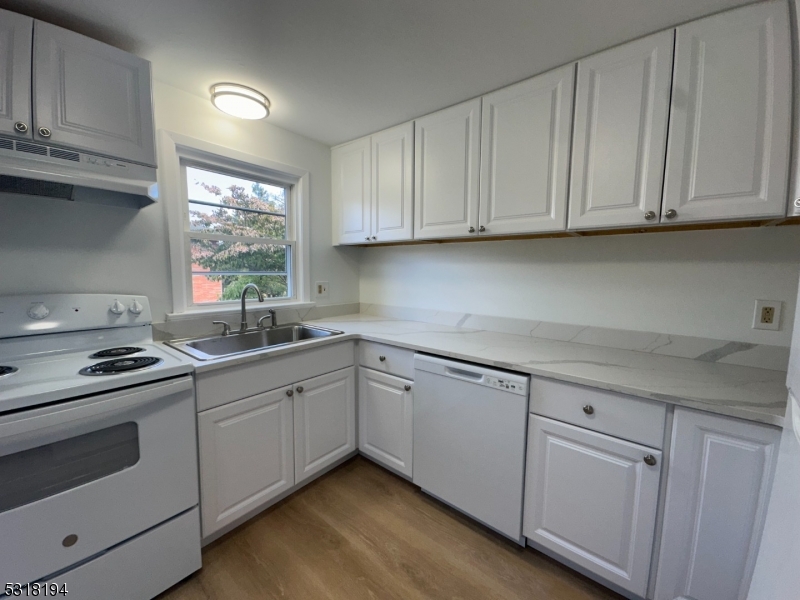 a kitchen with cabinets appliances a sink and a window