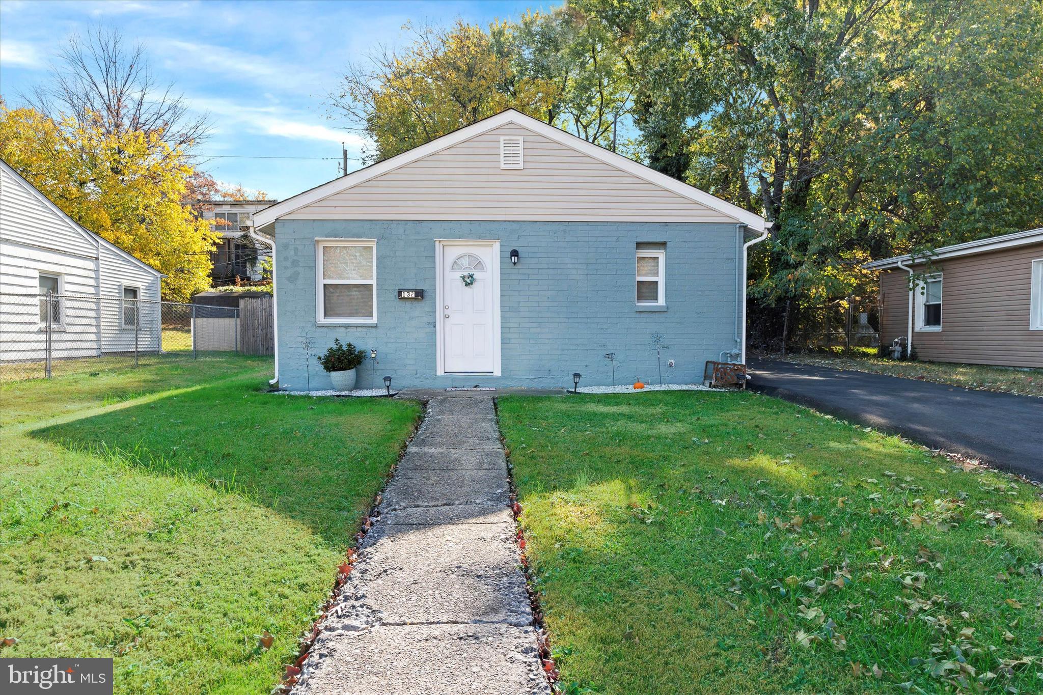 a view of a house with a yard and large tree