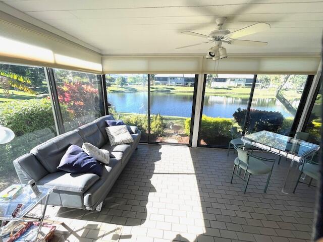 a living room with patio furniture and a floor to ceiling window