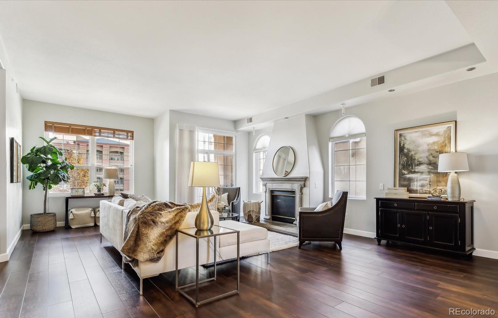 a living room with fireplace furniture and a large window