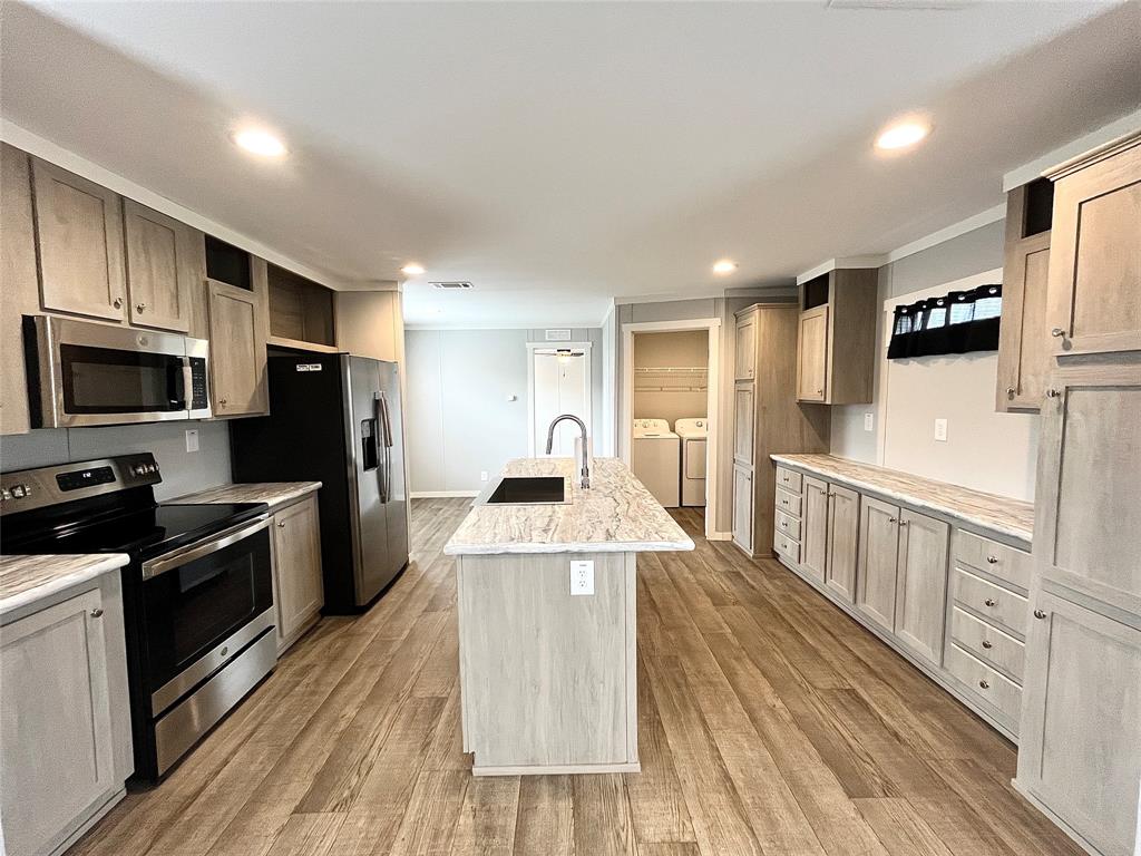 a large kitchen with stainless steel appliances granite countertop a stove and a sink