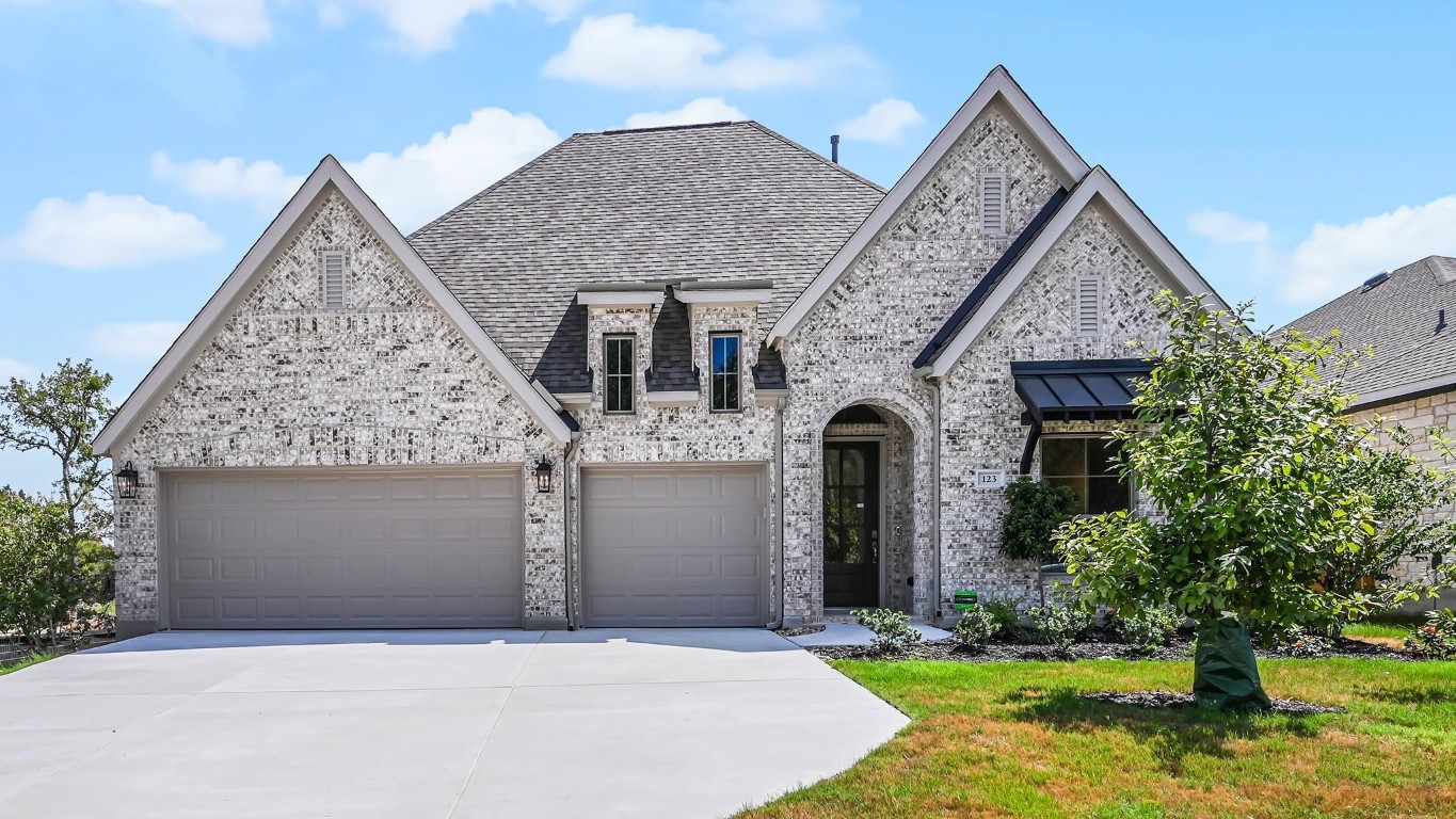 a front view of a house with yard and garage