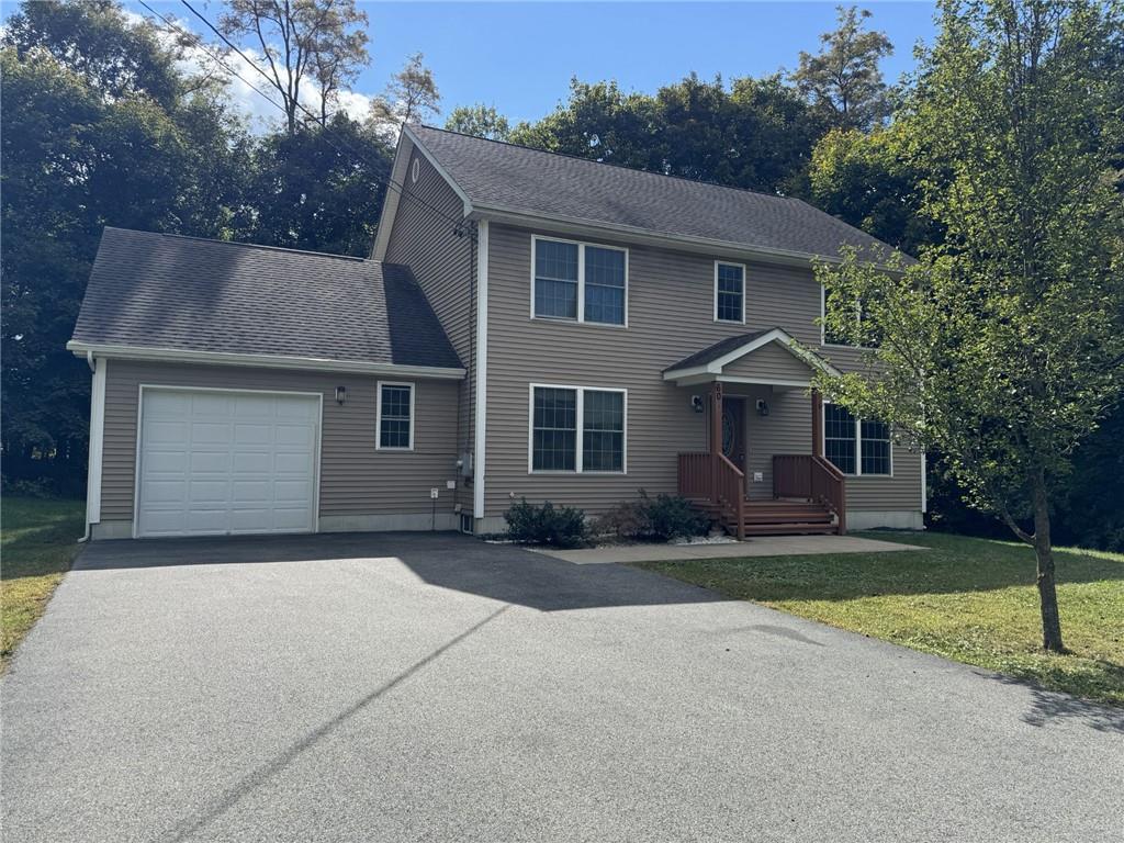 Colonial home with a garage and a front yard