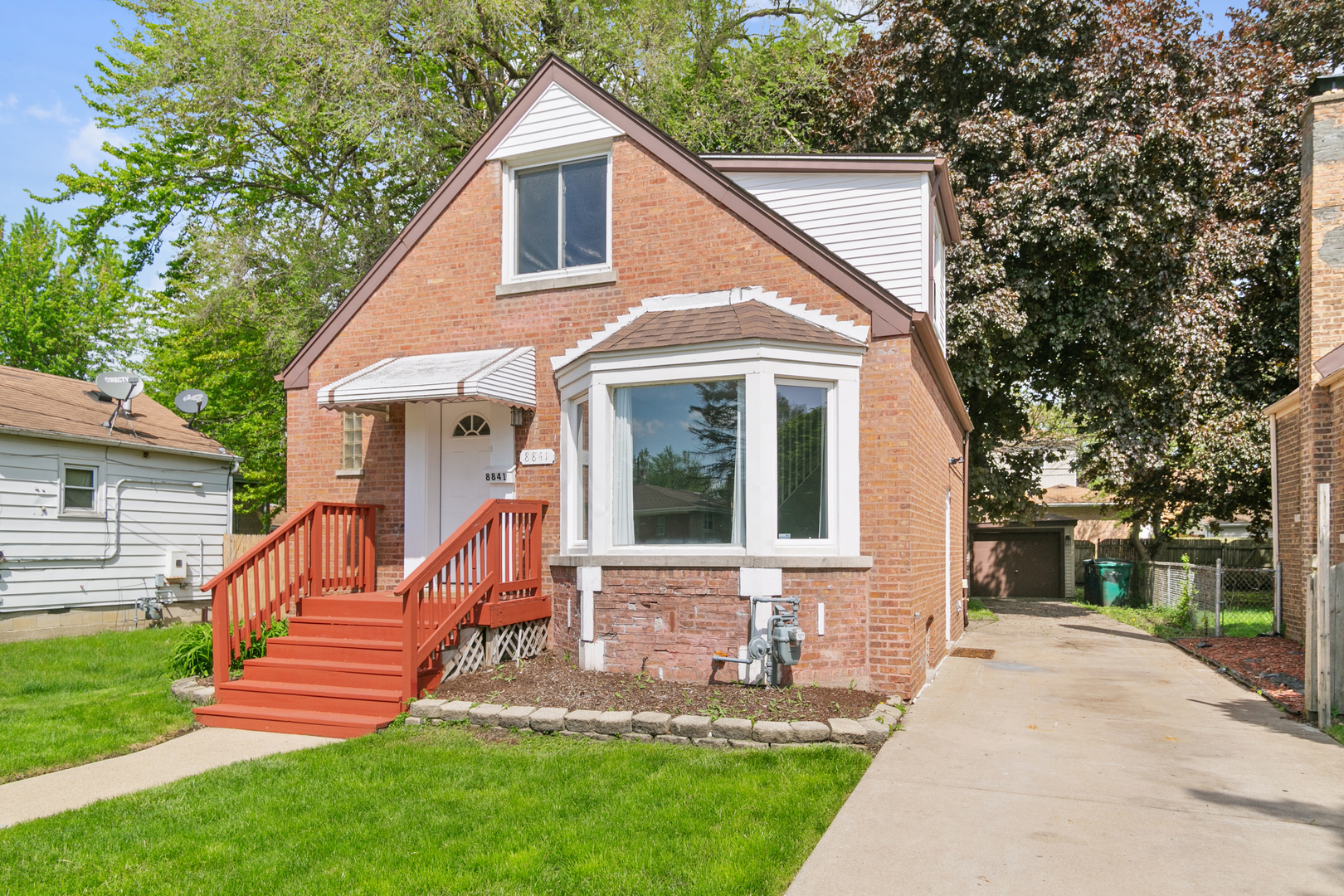 a front view of a house with yard and green space