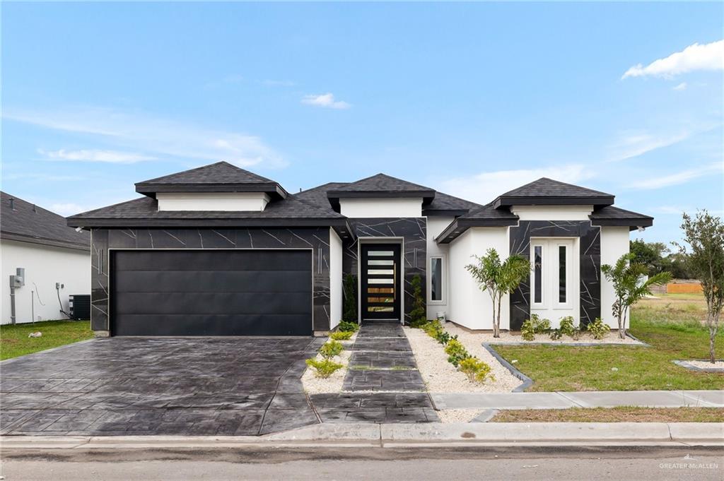 a front view of a house with a yard and garage