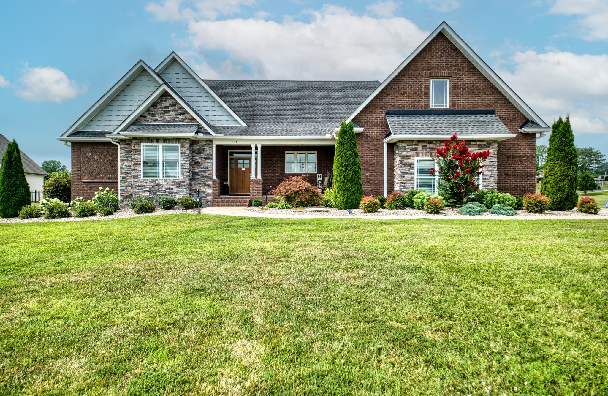 a front view of a house with yard and green space