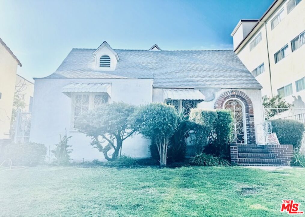 a front view of a house with a garden