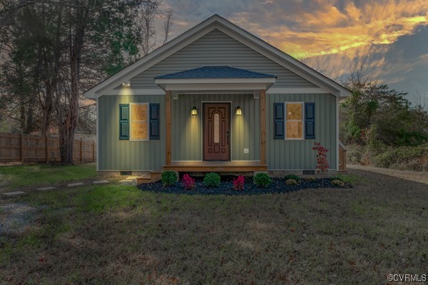 View of front of home featuring a porch and a yard