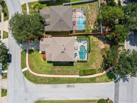 an aerial view of a residential houses with outdoor space and a lake view