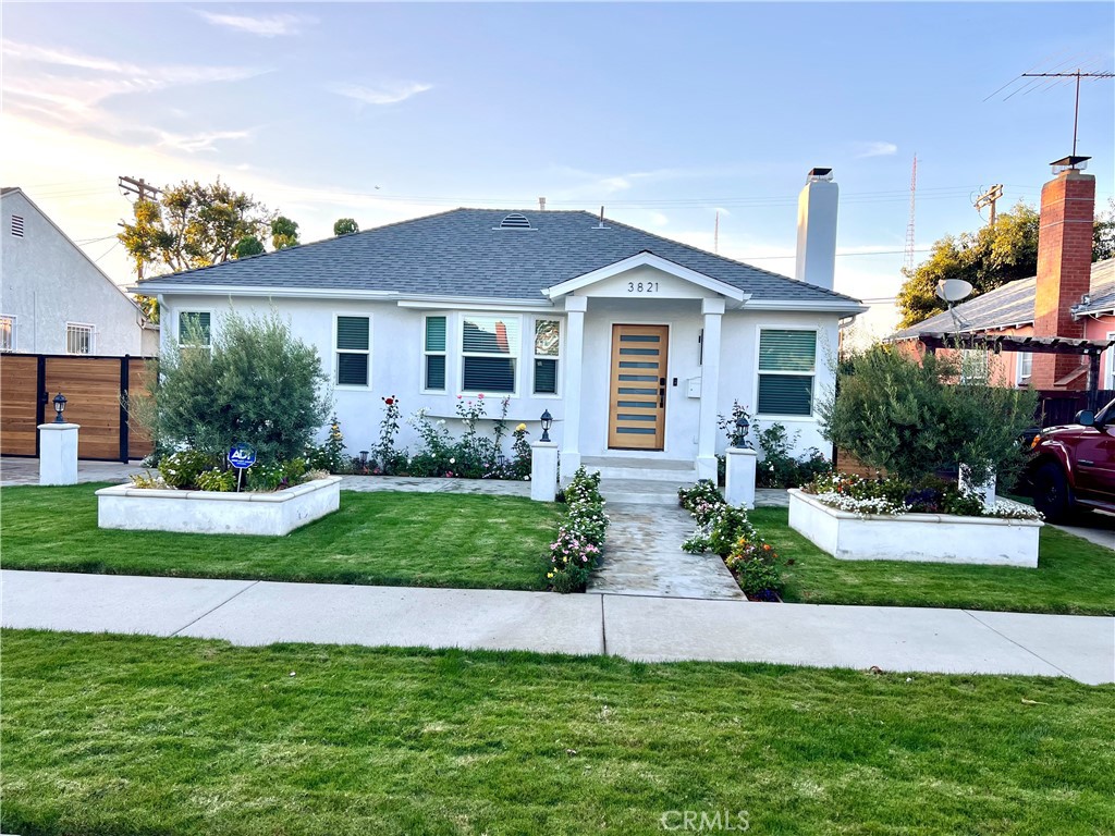 a front view of a house with a yard and potted plants