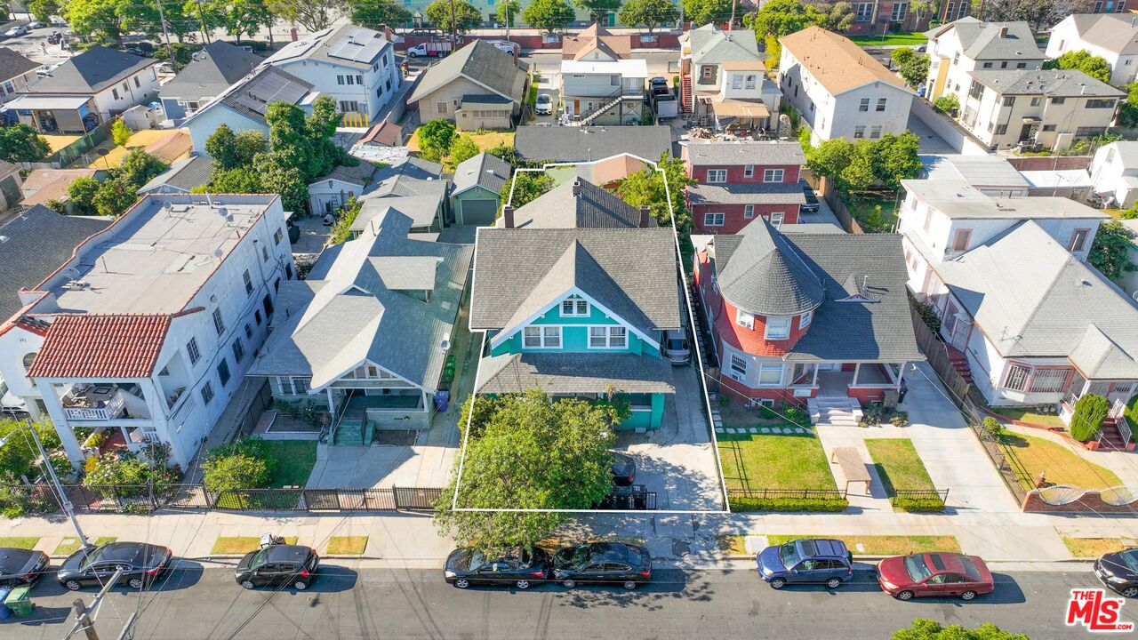 an aerial view of residential houses with cars parked