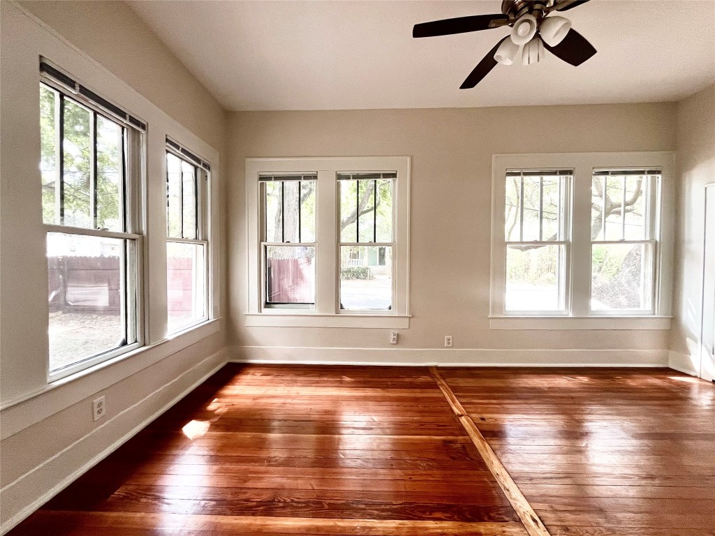 a view of empty room with wooden floor and window