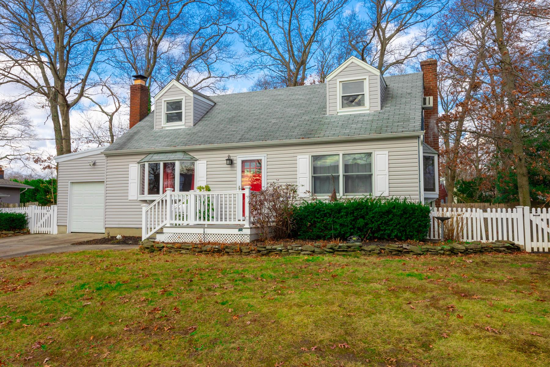 Cape cod-style house with a front lawn and a garage