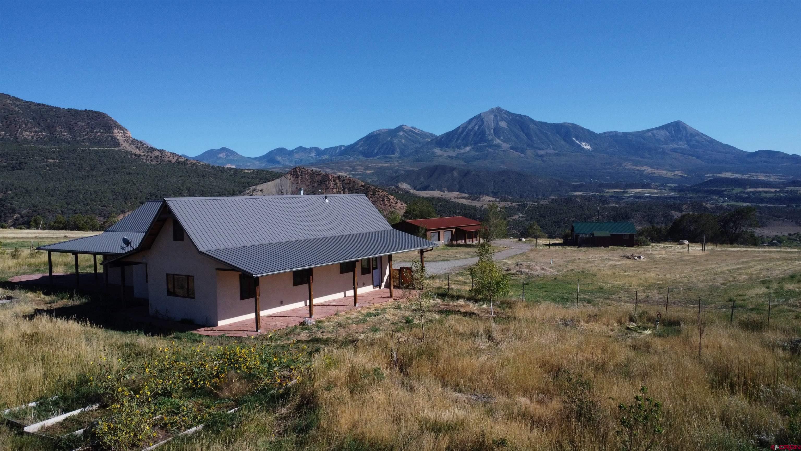 a view of house with green field and mountains