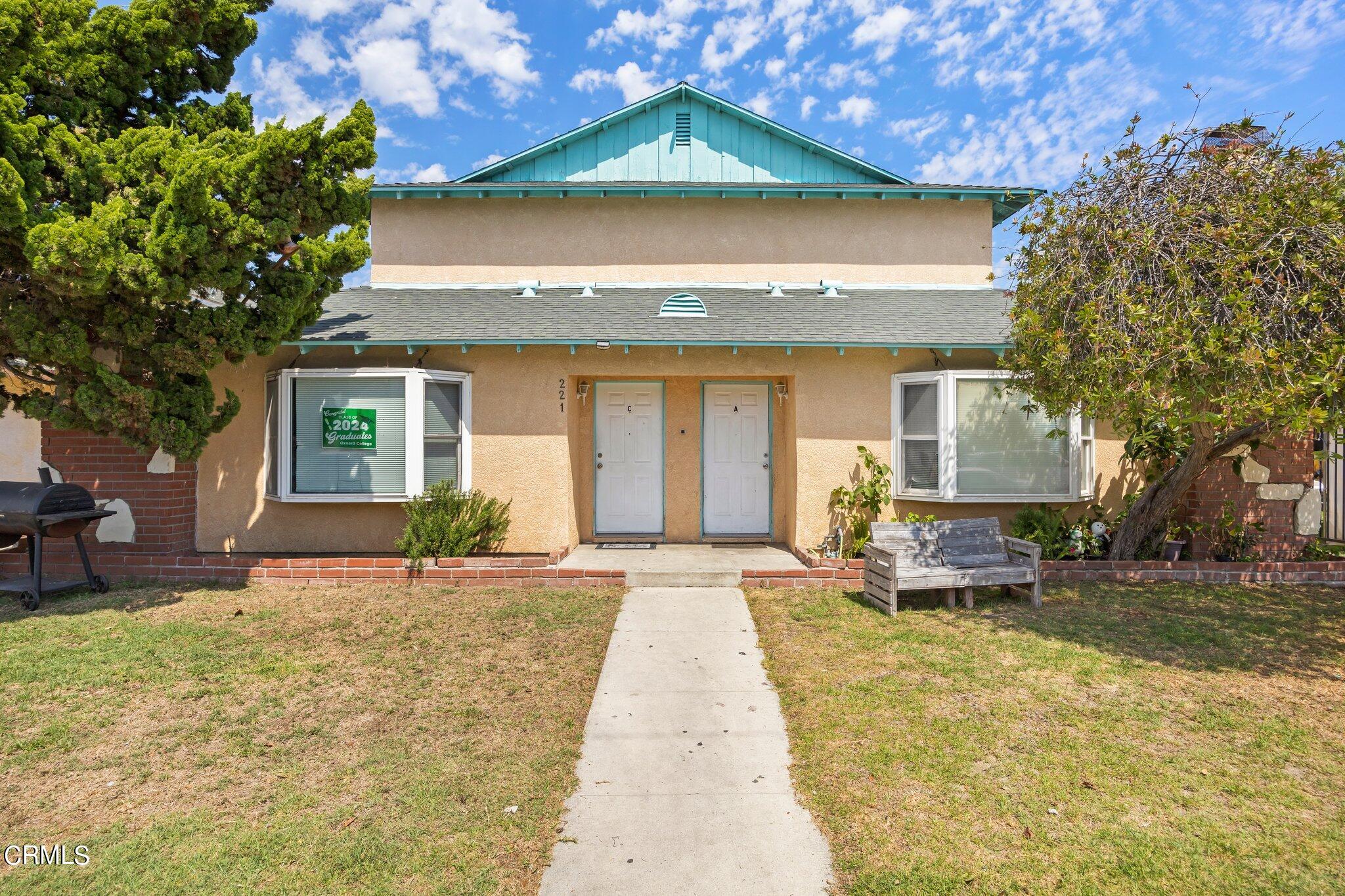 a front view of a house with a yard outdoor seating and garage