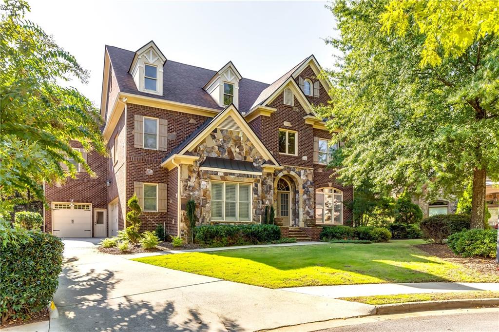 a view of a big house with a big yard and large trees