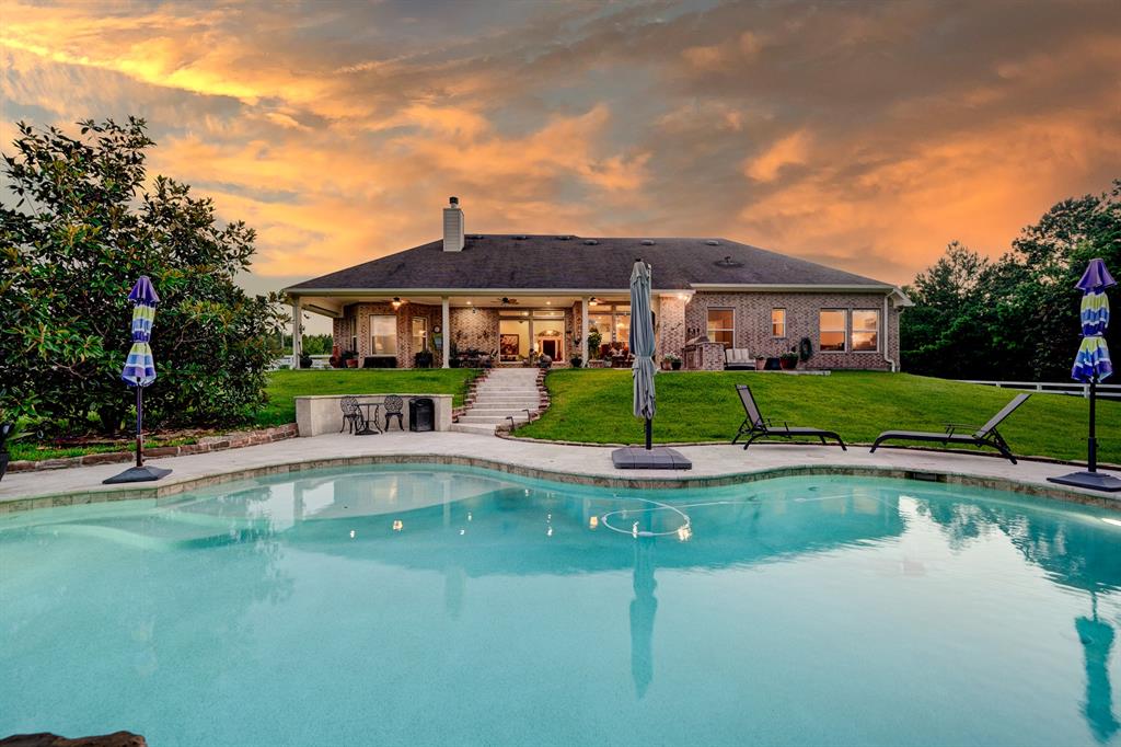 a view of a house with swimming pool and a yard