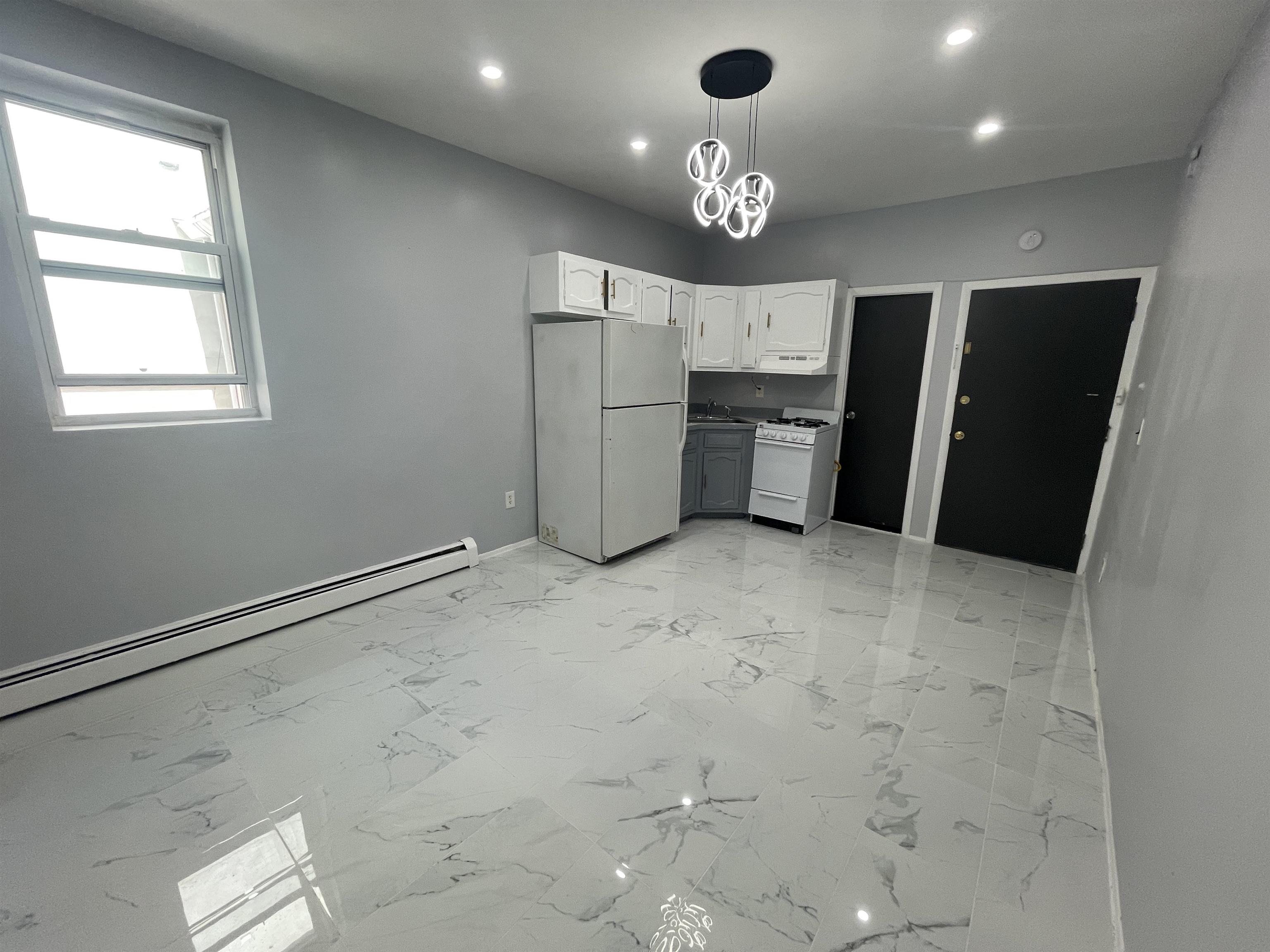 a view of a kitchen with a sink and refrigerator