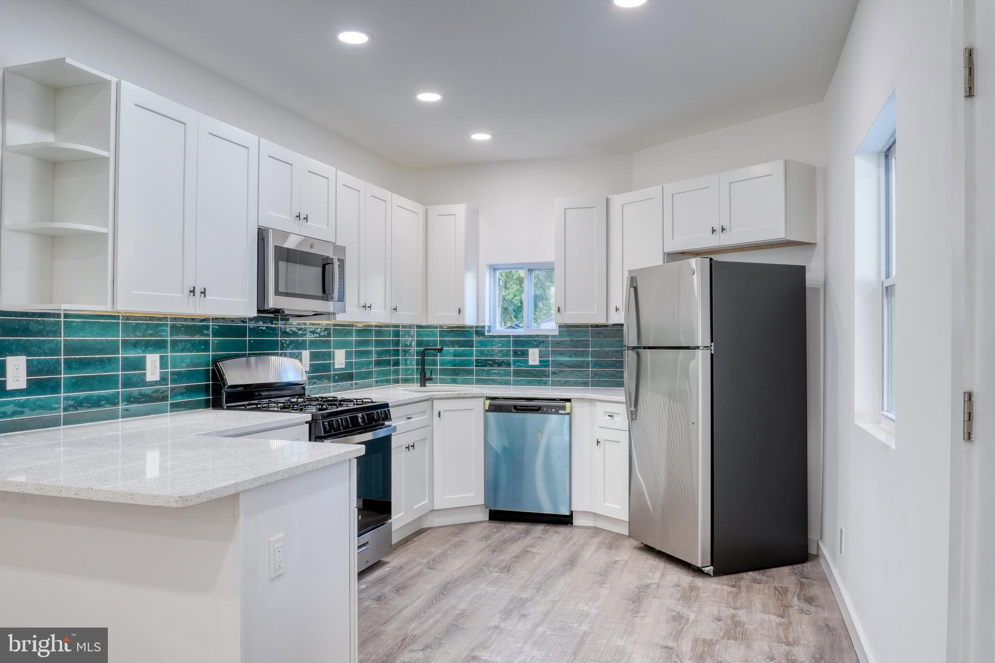 a kitchen with a refrigerator sink and white cabinets