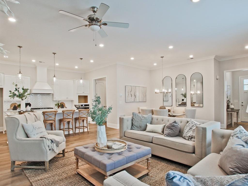 a living room with furniture kitchen view and a chandelier