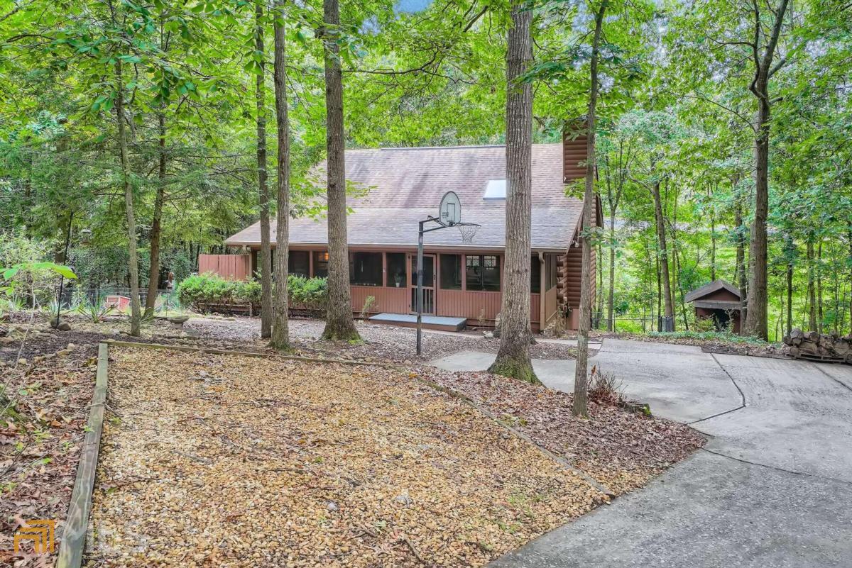 front view of a house with a tree next to a yard