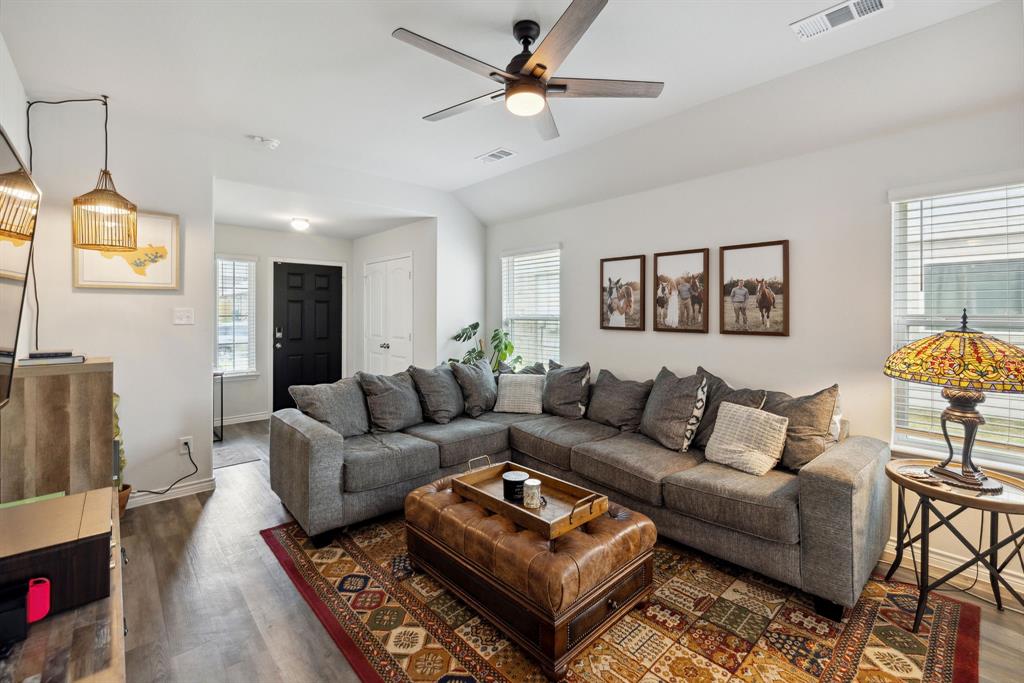 a living room with furniture a rug and a flat screen tv