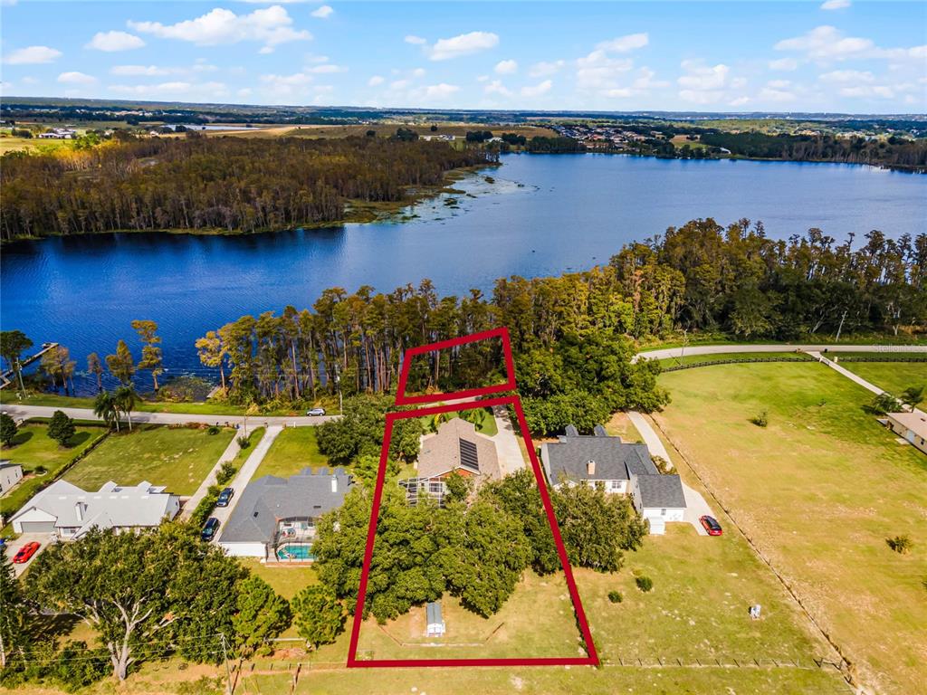 an aerial view of residential houses with outdoor space and lake view