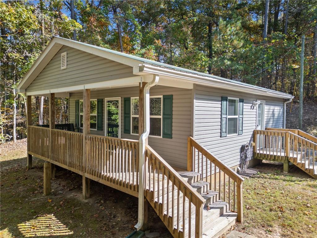 a view of a house with a wooden deck and a yard