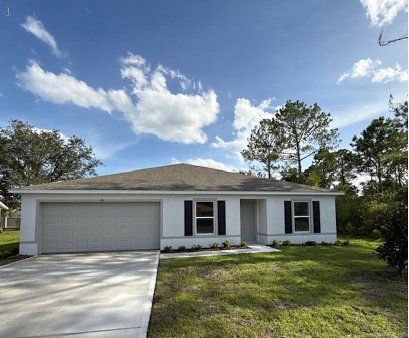 a view of a house with a yard and a garage