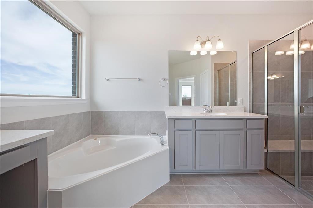 a bathroom with a tub sink and mirror