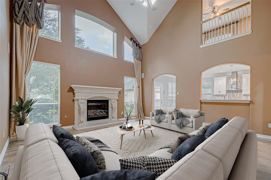 a living room with furniture a fireplace and a large window