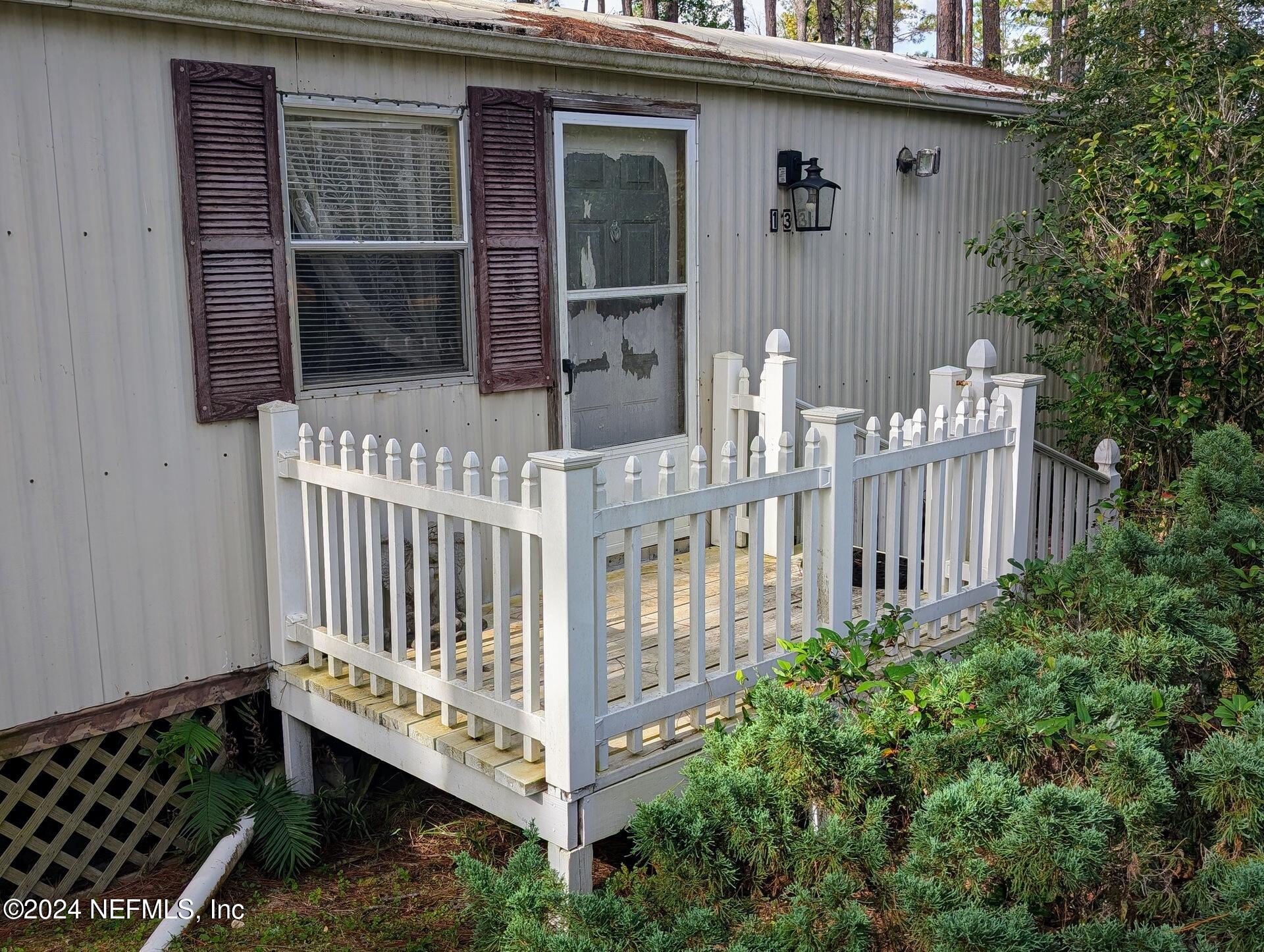 a view of a house with wooden fence and a porch