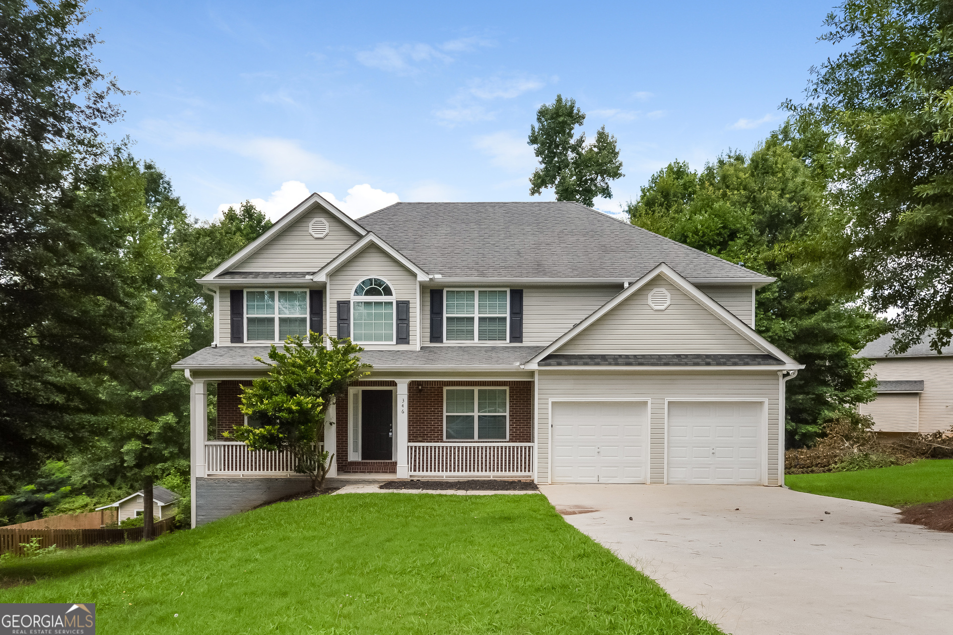 a front view of a house with a garden and yard