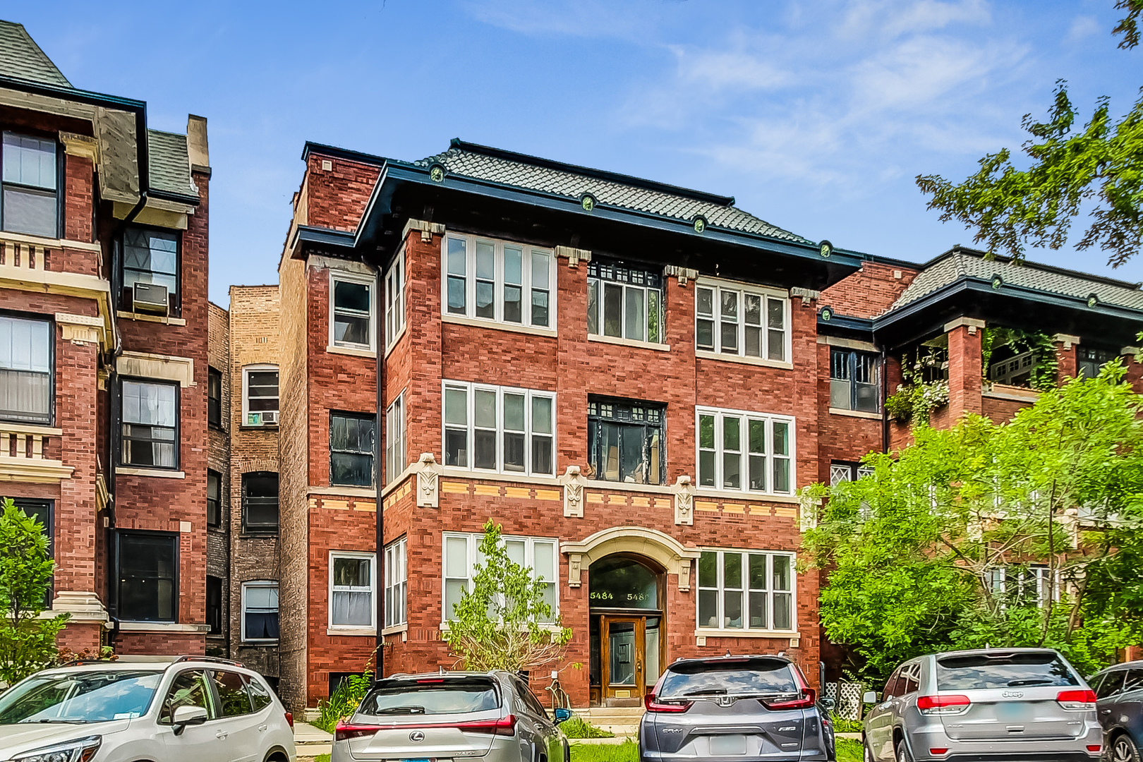 a front view of a residential apartment building with a yard